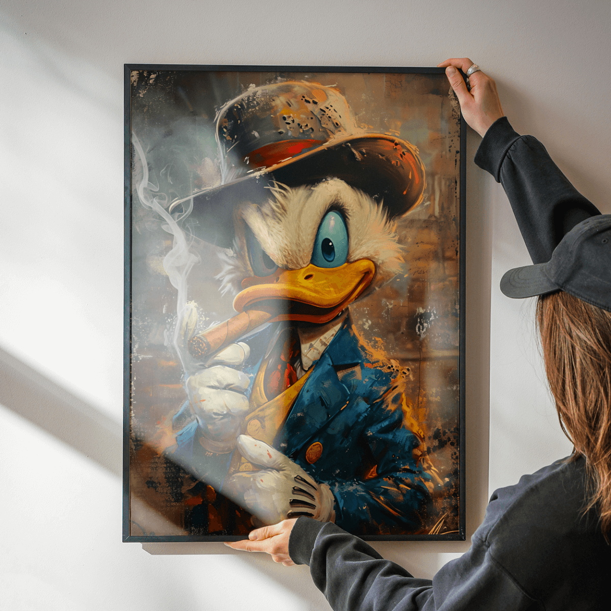 Person hängt ein personalisiertes Wandbild von Gangster Duck, einem stylischen Leinwand- und Metallbild, auf.