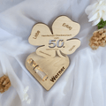 Nahaufnahme: Individuelle Gravur mit Name und Alter auf dem Kleeblatt aus Holz mit Geldring – einzigartiges Geschenk zum Geburtstag.